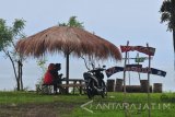 Pengunjung menikmati panorama di Pantai Jumiang, Pamekasan, Jawa Timur, Minggu (26/11). Pantai wisata yang berpotensi mendatangkan Pendapatan Asli Daerah (PAD) serta peningkatan taraf perekonomian warga setempat itu tidak terkelola dengan baik. Antara Jatim/Saiful Bahri/mas/17.
