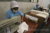 Pekerja membuat masker di pabrik alat kesehatan PT Kasa Husada Wira Jawa Timur, Surabaya, Jawa Timur, Selasa (28/11). Produksi maupun pesanan masker di pabrik yang merupakan Badan Usaha Milik Daerah (BUMD) Provinsi Jawa Timur itu masih belum mengalami peningkatan pasca erupsi Gunung Agung. Antara Jatim/Didik Suhartono/mas/17.