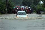 Sebuah mobil nekat menerobos saat melewati banjir di Desa Cot Girek Kandang, Muara Dua, Lhokseumawe, Aceh, Jumat (1/12). Banjir yang disebabkan tingginya intensitas hujan mengguyur provinsi Aceh sejak sepekan mengakibatkan sejumlah kabupaten/kota barat dan timur Aceh mulai teredam banjir. ANTARA FOTO/Rahmad/17.