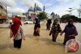 Warga melintasi banjir di Lhoksukon, Aceh Utara, Aceh, Senin (4/12. Banjir besar yang melanda wilayah timur Aceh Utara sejak Sabtu (2/12) meluas dan merendam 19 dari 27 kecamatan di Aceh Utara dengan ketinggian air 1-2,5 meter, Pemerintah setempat menetapkan Aceh Utara darurat banjir. (ANTARA FOTO/Rahmad/foc/17)