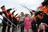 Pejabat lama Kapolda Kalbar, Irjen Pol Erwin Triwanto (kiri) melewati pedang pora saat mengikuti prosesi parade pelepasan di Mapolda Kalbar, Senin (4/12). Irjen Pol Erwin Triwanto yang digantikan Brigjen Pol Didi Haryono tersebut, selanjutnya akan bertugas sebagai Analis Kebijakan Utama Akademi Polisi Lemdiklat Polri. ANTARA FOTO/Jessica Helena Wuysang/17