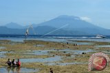 Kapal penyeberangan melintas di Selat Badung dengan latar belakang Gunung Agung yang dilihat dari Pantai Pantai Mahagiri, Nusa Lembongan, Bali, Kamis (7/12). Pusat Vulkanologi dan Mitigasi Bencana Geologi (PVMBG) menyatakan aktivitas Gunung Agung dalam level IV atau 'awas' karena masih terus aktif dan selama enam jam terakhir terjadi tremor terus menerus sehingga warga tetap diminta untuk waspada serta menghindari radius zona merah. ANTARA FOTO/Wira Suryantala/wdy/2017.