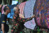 Pengamat Batik Madura, Mien A Rifai (kanan) didampingi Budayawan Madura, Ibnu Hajar (kiri) mengamati desain batik saat lomba desain batik dengan tajuk 'Sumenep Batik Festival' di Taman Bunga, Sumenep, Jawa Timur, Sabtu (9/12). Kegiatan yang juga dihadiri Puteri Indonesia 2016, Kezia Roslin Cikita Warouw itu dalam rangka bulan kunjungan ke Kabupaten Sumenep. Antara Jatim/Saiful Bahri/mas/17.