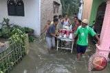 Beberapa orang mengevakuasi anggota keluarga mereka yang sakit sambil menerobos banjir, di Desa Sukadamai, Serdang Bedagai, Sumatera Utara, Senin (18/9/2017). ANTARASUMUT/Irsan Mulyadi/17