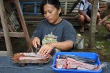 Lusia Irawati peternak ikan lele memisah daging ikan dari tulang dan kulit (fillet) di industri rumahan Aneka Olahan Lele Matrix, Sumbersari, Jember, Jawa Timur, Minggu (10/12). Rumah industri itu memproduksi makanan berbahan ikan lele hasil ternak sendiri menjadi olahan seperti abon, nugget, siomay, keripik, pastel abon, sumpia abon yang dijual mulai dari Rp9.000 - Rp25.000 per bungkus. Antara Jatim/Seno/mas/17.