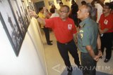 Kepala LKBN Antara Biro Jawa Timur Akhmad Munir (kiri) menunjukkan hasil karya foto pewarta foto LKBN Antara Biro Jawa Timur kepada Komandan Korem 084/ Bhaskara Jaya Kolonel Kav M. Zulkifli (kanan) saat perayaan HUT ke-80 LKBN Antara sekaligus pameran foto Retrospeksi Jawa Timur di kantor LKBN Antara Jawa Timur di Surabaya, Jawa TImur, Rabu (13/12). Dalam pameran Retrospeksi Jawa Timur 2017 tersebut menampilkan 80 karya foto para pewartafoto Antara di seluruh wilayah Jawa Timur dan 15 foto zaman kemerdekaan karya pewartafoto Abdul Wahab Saleh, juga peluncuran buku fotojurnalistik 'Retrospeksi Jawa Timur 2017'. Antara Jatim/Ari Bowo Sucipto/mas/17