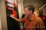 Konsul Jenderal Australia di Surabaya Chris Barnes menandatangani banner saat menghadiri pameran foto Retrospeksi Jawa Timur 2017 di kantor LKBN Antara Biro Jatim di Surabaya, Jawa Timur, Rabu (13/12). Irfan Anshori/Antara Jatim/mas/17.