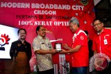 Direktur Network & IT PT Telkom Zulhelfi Abidin (kedua kanan) disaksikan Ketua DPRD Cilegon Faqih Usman Umar (kiri) dan didampingi Deputy Executive Vice President Infrastruktur Telkom Regional 2 Jakarta Soendojoadi (kanan) menyerahkan cendera mata Kepada Kadis Komimfo Cilegon Achmad Zubaedi (kedua kiri) usai meresmikan Jaringan Modern Smart City di Cilegon, Banten, Kamis (14/12). PT Telkom 100 persen menggunakan jaringan optik di Cilegon dan merupakan yang pertama di Jabbotabek yang mampu mentransfer data hingga 100 giga bite per detik. ANTARA FOTO/Af/Pd/17