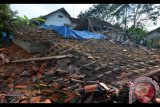 Warga menyaksikan rumah permanen berlantai dua yang ambruk akibat gempa bumi di Desa Gunung Sari, Jawa Barat, Sabtu (16/12). Gempa berkekuatan 6,9 skala richter pada Jumat (15/12) malam mengakibatkan satu orang meninggal dunia dan enam luka-luka serta 23 rumah rusak berat dan ringan. Antara Foto/Adeng Bustomi/nym/2017.