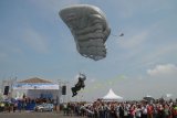 Sejumlah pengunjung mengamati prajurit TNI AL terjung payung yang akan mendarat ketika Naval Base Open Day (NBOD) 2017 di Dermaga Ujung Koarmatim, Surabaya, Jawa Timur, Minggu (17/12). Sejumlah atraksi dan alutsista ditampilkan prajurit TNI AL dalam rangka memeriahkan Hari Armada Republik Indonesia 2017. Antara Jatim/M Risyal Hidayat/mas/17.