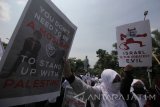 Massa dari Gerakan Masyarakat Peduli Palestina (Gempa) berunjuk rasa di depan Gedung Negara Grahadi, Surabaya, Jawa Timur, Minggu (17/12). Massa aksi mengutuk keras sikap Presiden Amerika Serikat Donald Trump atas pemindahan Kedubes AS dari Tel Aviv ke Yerusalem. Antara Jatim/Didik Suhartono/mas/17.