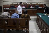 Terdakwa Bupati Pamekasan nonaktif Achmad Syafii (tengah) menjalani sidang putusan kasus suap proyek Desa Dassok sebesar Rp 250 Juta terhadap Kajari Pamekasan terkait penanganan dugaan korupsi dana desa Pamekasan di Pengadilan Tindak Pidana Korupsi (tipikor) Surabaya di Juanda, Sidoarjo, Jawa Timur, Senin (18/12). Majelis hakim menjatuhkan vonis pidana penjara selama dua tahun delapan Bulan dan denda Rp 50 Juta. Antara Jatim/Umarul Faruq/mas/17.