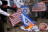 Sejumlah pengunjuk rasa dari gabungan Ormas Islam di Aceh membakar bendera Israel dan Amerika Serika saat aksi damai membela Palestina Merdeka di gedung DPR Aceh, Banda Aceh, Senin (18/12). Sebanyak 23 Ormas Islam di Aceh mengutuk presiden Amerika Serikat, Donald Trump atas pernyataan sepihak mengakui Yerussalem sebagai ibukota Israel, dan mendesak umat Islam di seluruh dunia termasuk Indonesia bersatu memperjuangkan kemerdekaan Palestina dari zionis Israel. (ANTARA FOTO/Ampelsa/ama/17)