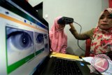 Petugas merekam data identitas retina mata warga pemula saat pengurusan KTP-elektronik di kantor kepala desa Keude Aceh, Banda Sakti, Lhokseumawe, Aceh, Senin (18/12). Menteri Dalam Negeri Tjahjo Kumolo menargetkan 184 juta jiwa warga negara yang sudah berusia 17 tahun sudah memiliki KTP-el pada Januari 2018, untuk meningkatkan partisipasi pemilihan anggota legislatif serta pemilihan presiden dan wakil presiden 2019. (ANTARA FOTO/Rahmad/ama/17)