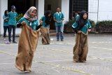 Sejumlah mahasiswi adu kecepatan dalam lomba balap karung ketika mengikuti lomba permainan tradisional di STIE Perbanas Surabaya, Jawa Timur, Jumat (22/12). Lomba permainan tradisional tersebut rangkaian memeriahkan Hari Ibu 2017 sekaligus Dies Natalis ke-48 STIE Perbanas. Antara Jatim/M Risyal Hidayat/mas/17.
