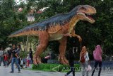 Sejumlah pengunjung mengamati patung Dinosaurus di Atlantis Land, Surabaya, Jawa Timur, Senin (25/12). Wahana wisata baru tersebut ramai dikunjungi oleh warga yang berasal dari Surabaya maupun dari daerah lain di Jawa Timur untuk memanfaatkan liburan Natal dan Tahun Baru 2018. Antara Jatim/Didik Suhartono/mas/17.