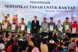 Presiden Joko Widodo (enam kanan) didampingi Menteri Agraria & Tata Ruang/Kepala Badan Pertanahan Nasional (BPN), Sofyan Djalil (lima kanan) berfoto bersama sejumlah penerima sertifikat tanah saat acara penyerahan sertifikat tanah untuk rakyat di Masjid Raya Mujahidin, Pontianak, Kalbar, Kamis (28/12). Sebanyak 1.080.950 sertifikat tanah dibagikan untuk rakyat di tujuh provinsi yaitu Kalimantan Barat, Jawa Timur, Sulawesi Selatan, Sulawesi Tengah, Jambi, Lampung, dan Sumatera Selatan. ANTARA FOTO/Jessica Helena Wuysang/17