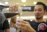 Seorang barista menuang kopi ke dalam gelas kertas yang akan dibagikan kepada pengunjung pada Indonesia Coffee Events (ICE) 2018 di Surabaya, Jawa Timur, Minggu (21/1). Kegiatan tersebut selain menjadi ajang memperkenalkan kopi nusantara kepada masyarakat juga ajang pertemuan barista antar daerah untuk saling bertukar cerita dan pengalaman. ANTARA FOTO/Zabur Karuru/wdy/2018