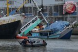 Anak Buah Kapal mengevakuasi muatan Kapal Layar Motor (KLM) Mayang Sari yang kandas, ke KLM Mina Abadi di muara Sungai Kalimas, Pelabuhan Rakyat Kalimas, Surabaya, Jawa Timur, Minggu (21/1). Menurut pengakuan nahkoda KLM Mayang Sari, kapal pengangkut kargo campuran (general cargo) termasuk kebutuhan pokok tujuan Surabaya - Balikpapan itu kandas saat memasuki Pelabuhan Rakyat Kalimas usai menghindari cuaca buruk di sekitar Karang Jamuang. ANTARA FOTO/Didik Suhartono/ama/18