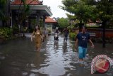 Sejumlah guru dan pegawai meninjau banjir di SMP 6 Denpasar, Selasa (23/1). Sejumlah sekolah di Kota Denpasar seperti SMP 6 Denpasar, SD 14 Denpasar, SD 9 Denpasar terpaksa dilburkan sementara karena seluruh ruang belajar siswa dan akses menuju sekolah tergenang banjir. Antara Foto/Wira Suryantala/nym/2018.