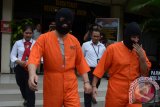 Polisi menggiring warga negara Rusia Balmus Petru (depan kanan) dan warga Negara Tiongkok Xiao Xiaofei (depan kiri) yang menjadi tersangka kasus penipuan saat gelar perkara di Mapolda Bali, Rabu (24/1). Polisi berhasil membekuk kedua warga negara asing tersebut saat berlibur di Bali atas permintaan pemerintah Moldova dan Tiongkok karena terlibat kasus penipuan dan menjadi daftar pencarian orang di negara tersebut. ANTARA FOTO/Wira Suryantala/18.