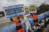 Sejumlah aktivis lingkungan hidup yang tergabung dalam Ecoton membentangkan poster ketika menggelar aksi 'jangan buang popok di Jembatan Sepanjang', Surabaya, Jawa Timur, Selasa (16/1). Dalam aksinya mereka menghimbau masyarakat agar tidak membuang sampah popok ke sungai karena dapat merusak lingkungan dan berdampak buruk pada biota sungai tersebut. Antara Jatim/Zabur Karuru/zk/18 