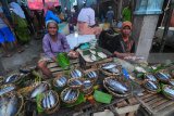 Pedagang menunggui ikan dagangannya di Pasar 17 Aguatis, Pamekasan, Jawa Timur, Kamis (25/1). Dalam sepekan terakhir harga ikan naik sekitar 35 persen dari sebelumnya karena pasokan ikan dari Pantura Jatim minim akibat musim angin barat. Antara Jatim/Saiful Bahri/zk/18.