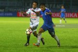 Pesepakbola Arema FC, Ridwan Tawainela (kiri) berebut bola dengan pesepakbola PSIS Semarang, Frendy Saputra (kanan) dalam Turnamen Piala Presiden di Stadion Kanjuruhan, Malang, Jawa Timur, Kamis (25/1). Di akhir babak pertama, Arema sementara unggul atas PSIS dengan skor 2-0. Antara Jatim/Ari Bowo Sucipto/zk/18. 