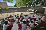 Siswa SDN Pusapasari mengikuti kegiatan belajar mengajar menggunakan tenda darurat di Desa Sundawenang, Kabupaten Tasikmalaya, Jawa Barat, Selasa (2/1). Akibat lima ruang kelas rusak berat karena diguncang gempa berkuatan 6,9 skala richter pada Jumat (15/12/2017) malam, siswa SDN Puspasari terpaksa belajar di tenda meskipun dalam kondisi panas dan berdebu dan berharap ada bantuan dari Pemerintah untuk membangunkan ruang kelas yang baru. ANTARA JABAR/Adeng Bustomi/18 
