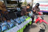 Warga membeli beras kualitas super seharga Rp10.200 per kilogram saat operasi pasar murni yang diselenggarakan oleh Tim Pengendali Inflasi Daerah (TPID) di depan Taman Makam Pahlawan, Kota Kediri, Jawa Timur, Selasa (30/1). Penjualan beras murah oleh TPID bekerjasama dengan Pemerintah daerah setempat, Bank Indonesia, dan Satgas Pangan Kepolisian itu sepi pembeli karena kurang sosialisasi. Antara jatim/Prasetia Fauzani/zk/18