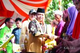 Gubernur Kalimantan Selatan H. Sahbirin Noor secara simbolis menyerahkan kunci bedah rumah kepada keluarga Bahrudin, warga Desa Lok Serampang, Kelurahan Pelaihari, Kabupaten Tanah Laut Sabtu (27/1). Foto:Antaranews Kalsel/Arianto/G.