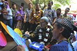 Gubernur Jawa Barat Ahmad Heryawan (kedua kanan) melukis motif payung geulis pada acara seminar dan bazar kewirausahaan di SMAN 1 Kota Tasikmalaya, Jawa Barat, Selasa (9/1). Bazar yang memamerkan hasil karya siswa bertujuan untuk memotivasi anak agar siswa SMA membuat inovasi teknologi tepat guna. ANTARA JABAR/Adeng Bustomi