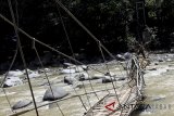 Personel TNI melintasi jembatan gantung yang ambruk menghubungkan Desa Sirna Sari dan Desa Buana Jaya, Tanjung Sari, Bogor, Jawa Barat, Selasa (2/1). Jembatan gantung sebagai penghubung desa serta akses penyebrangan wisata penangkaran rusa ambruk pada tanggal (1/1) diduga karena kelebihan beban dan mengakibatkan 30 korban satu diantaranya meninggal dunia. ANTARA JABAR/Yulius Satria Wijaya