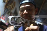 Pengrajin menunjukan kacamata hasil karyanya  di sebuah industri rumahan di Bandungrejosari, Malang, Jawa Timur, Jumat (19/1). Industri kacamata kayu rumahan tersebut dibentuk oleh sebuah Lembaga Swadaya Masyarakat (LSM) untuk melatih dan mewadahi para mantan napi serta pecandu narkoba guna berkreasi sekaligus menjadi pengrajin sehingga mudah diterima kembali di masyarakat. Antara Jatim/Ari Bowo Sucipto/zk/18. 