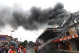 Sejumlah petugas PMK berusaha memadamkan api yang membakar toko perlengkapan olahraga SportStation dan SportMania di Dinoyo, Malang, Jawa Timur, Sabtu (20/1). Meski tidak ada korban jiwa, kebakaran tersebut mengakibatkan kerugian diperkirtakan mencapai Rp2 miliar. Antara Jatim/Ari Bowo Sucipto/zk/18.