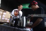 Barista membuatkan kopi gratis pada seorang penumpang dalam kegiatan Ngopi Bareng KAI 50K di Stasiun Kotabaru, Malang, Jawa Timur, Rabu (31/1). Kegiatan membagikan 50.000 cup kopi gratis tersebut diadakan untuk mengenalkan citarasa kopi khas Indonesia pada para penumpang di 13 stasiun di 11 kota mulai dari Stasiun Gambir-Jakarta hingga Stasiun Jember. Antara jatim/Ari Bowo Sucipto/zk/18.