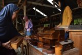 Pembeli memilih cendera mata hasil kerajinan berbahan kayu jati di Banjarejo, Kedunggalar, Kabupaten Ngawi, Jawa Timur, Kamis (25/1). Hasil kerajinan berupa cendera mata, hiasan ruangan hingga perabot meja dan kursi berbahan kayu jati tersebut oleh pembelinya dijual dengan harga antara Rp40 ribu perbuah hingga Rp25 juta persetel. Antara Jatim/Foto/Siswowidodo/zk/18
