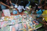 Sejumlah anak memilih buku bacaan di lapak komunitas Baca Buku di depan stadion Candra Bhirawa Pare, Kediri, Jawa Timur, Minggu (21/1). Komunitas yang dibentuk oleh sejumlah mahasiswa itu menyediakan buku bacaan bermutu yang didapat dari donatur guna dipinjamkan secara gratis untuk umum. Antara Jatim/Prasetia Fauzani/zk/18