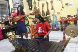 Siswa SMP Kristen Pamerdi memainkan alat musik tradisional yang dipajang di Museum Musik Indonesia di Malang, Jawa Timur, Senin (29/1). Kegiatan tersebut merupakan upaya untuk mengenalkan warisan musik nusantara termasuk alat musik tradisional serta piringan hitam dari musisi klasik Indonesia pada para pelajar. Antara jatim/Ari Bowo Sucipto/zk/18.