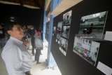 Pengunjung menyaksikan karya foto yang dipajang dalam pameran foto bertajuk Balada Tepian Kota, di Surabaya, Jawa Timur, Senin (22/1). Pameran 31 foto karya dua mahasiswa Sekolah Tinggi Komunikasi-Almamater Wartawan Surabaya (Stikosa-AWS) tersebut menampilkan suasana pinggiran kota Surabaya yang berlangsung hingga 28 Januari. Antara Jatim/Moch Asim/zk/18 