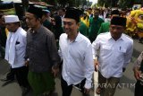 Bakal Calon Wali Kota Aizzudin Abdurrahman (ke dua kiri) dan Bakal Calon Wakil Wali Kota Sujono Teguh Wijaya (ke dua kanan) berjalan berdampingan diiringi puluhan pendukungnya untuk melakukan pendaftaran Pilkada 2018 menuju kantor KPU di Kota Kediri, Jawa Timur, Rabu (10/1). Pasangan Bakal Calon Wali Kota dan Wakil Wali Kota dari kalangan santri dan tionghoa tersebut diusung oleh koalisi PKB, Golkar, PPP, dan Gerindra. Antara jatim/Prasetia Fauzani/zk/18