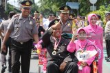 Pensiunan polisi beserta istri menaiki becak yang dikemudikan oleh Kapolresta Kediri AKBP Anthon Haryadi (tengah) melintas di salah satu jalan protokol Kota Kediri, Jawa Timur,Jumat (26/1). Pawai dengan menggunakan becak hias tersebut sebagai simbolisasi penghargaan dan ucapan terima kasih keluarga besar polres Kediri kepada anggota yang telah memasuki purna tugas. Antara jatim/Prasetia Fauzani/zk/18