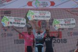 Juara pertama pada etape tiga Kastrantas Charlampos (kedua kiri) dari tim Java Partizan bersama pemenang kedua Projo Waseso (kiri) dari Indonesia National Team dan pemenang ketiga Asal Indonesia Arifin Muhammad Imam dari KFC Cycling Team foto bersama di atas panggung di Taman Blambangan, Banyuwangi, Jawa Timur, Sabtu (27/1). Kastrantas Charlampos menjadi yang tercepat pada etape-3 diikuti dua pebalap asal Indonesia, setelah menempuh jalur terpanjang 200 kilometer pada lanjutan ajang Tour De Indonesia 2018. Antara Jatim/Budi Candra Setya/zk/18.