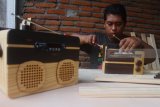 Pengrajin membuat radio dari kayu limbah pabrik di Malang, Jawa Timur, Jumat (19/1). Radio kayu yang dijual Rp 500 ribu per unit tersebut dipasarkan hingga ke berbagai daerah terutama Jakarta, Bandung dan Makassar. Antara Jatim/Ari Bowo Sucipto/zk/18. 