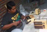 Pengrajin membuat radio dari kayu limbah pabrik di Malang, Jawa Timur, Jumat (19/1). Radio kayu yang dijual Rp 500 ribu per unit tersebut dipasarkan hingga ke berbagai daerah terutama Jakarta, Bandung dan Makassar. Antara Jatim/Ari Bowo Sucipto/zk/18. 