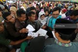 Sejumlah warga berdesakan mengambil zakat di Gor Jayabaya, Kota Kediri, Jawa Timur, Senin (29/1). Badan Amil Zakat Nasional (Baznas) menyalurkan zakat mal kepada 2.050 mustahiq (penerima zakat) se-Kota Kediri dalam bentuk beasiswa, bedah rumah, santunan; dan berbagai model program ekonomi. Antara Jatim/Prasetia Fauzani/zk/18