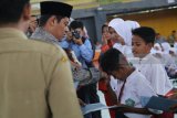 Wali Kota Kediri Abdullah Abu Bakar (kiri) secara simbolis menyalurkan zakat di Gor Jayabaya, Kota Kediri, Jawa Timur, Senin (29/1). Badan Amil Zakat Nasional (Baznas) menyalurkan zakat mal kepada 2.050 mustahiq (penerima zakat) se-Kota Kediri dalam bentuk beasiswa, bedah rumah, santunan; dan berbagai model program ekonomi. Antara jatim/Prasetia Fauzani/zk/18