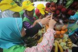 Sejumlah murid SD Muhammadiyah 15 Surabaya mengambil buah saat acara 'royokan' atau rebutan buah bergizi, di Surabaya, Jawa Timur, Kamis (25/1). Kegiatan yang diselenggarakan dalam rangka memperingati Hari Gizi Nasional yang ke-58 tersebut bertujuan untuk mengajarkan dan membiasakan para murid untuk mengkonsumsi makanan dan hidup sehat. Antara jatim/Moch Asim/zk/18