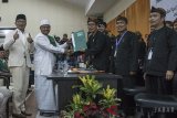 Bakal calon Gubernur Jawa Barat Ridwan Kamil (kiri) bersama bakal calon Wakil Gubernur Jawa Barat Uu Ruzhanul Ulum (kedua kiri) memberikan berkas pendafaran kepada Ketua Komisi Pemilihan Umum (KPU) Jawa Barat Yayat Hidayat (ketiga kiri) saat pendaftaran pasangan calon pemilu gubernur Jabar 2018 di Kantor KPU Jawa Barat, Bandung, Jawa Barat, Selasa (9/1). Pasangan Ridwan Kamil dan UU Ruzhanul Ulum dengan singkatan RINDU tersebut diusung oleh empat Partai yakni Partai Nasdem, Hanura, PPP dan PKB. ANTARA JABAR/Novrian Arbi