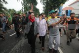 Wali Kota Surabaya Tri Rismaharini (ketiga kanan) bersama bakal calon Wakil Gubernur Jawa Timur Puti Guntur Soekarno (keempat kanan) berjalan santai menikmati suasana Car Free Day (CFD) Darmo, Surabaya, Jawa Timur, Minggu (21/1). Kehadiran mereka berdua di kawasan itu mendapat sambutan dari pengunjung CFD. Antara Jatim/Didik Suhartono/zk/18